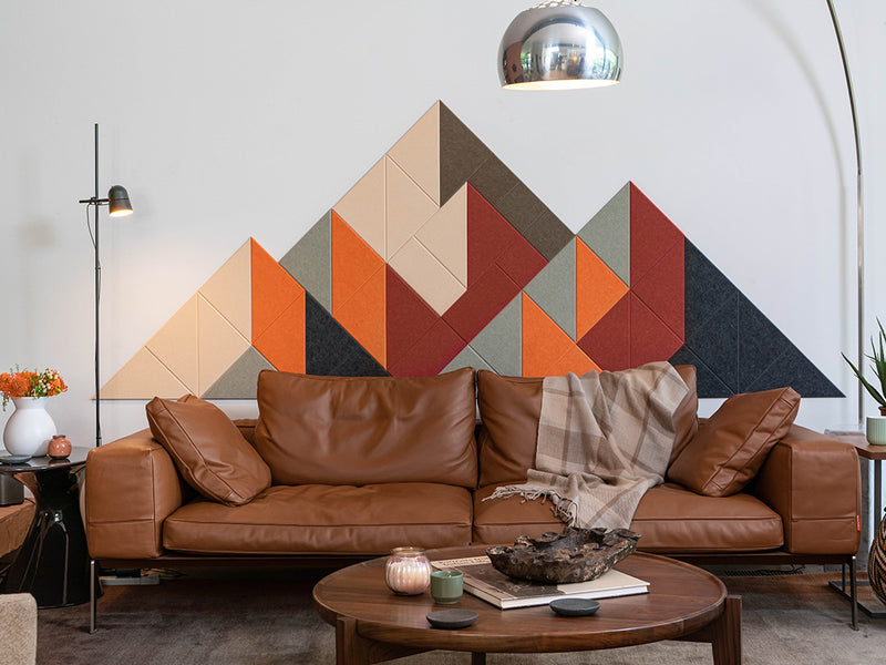 Brown leather sofa with a geometric headboard in a living room setting.