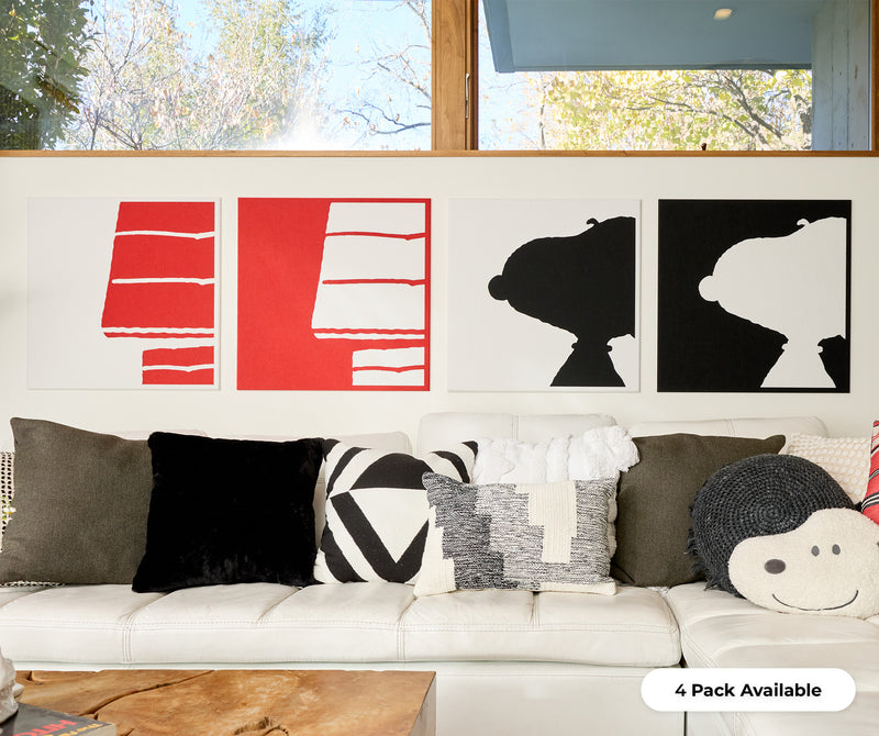 4 pack of snoopy and his doghouse installed on the wall above a couch.