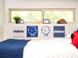 Bedroom with Snoopy plush toy and decorative pillows on a bed, featuring Charlie Brown illustrations on the wall.