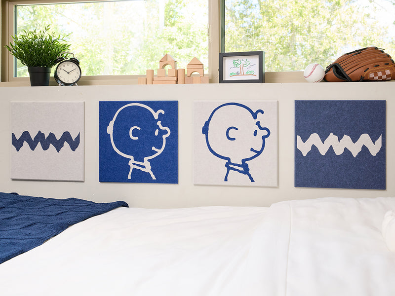 Bedroom with Snoopy plush toy and decorative pillows on a bed, featuring Charlie Brown illustrations on the wall.