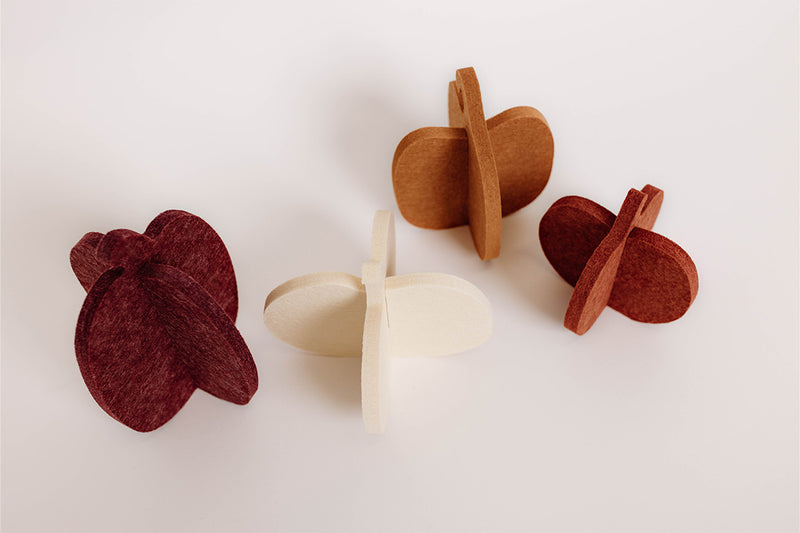 Set of four felt pumpkins in different colors on a white background