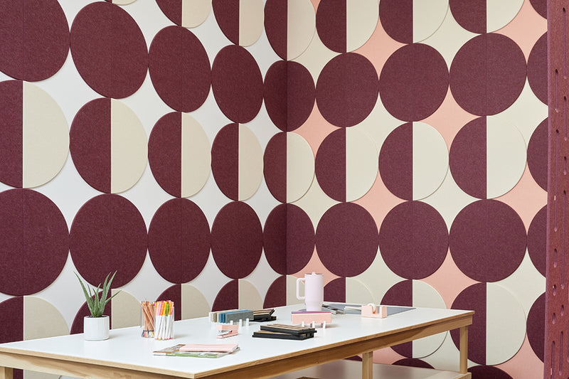 A Felt Right wall art design in shades of pink purple and cream circle tiles creating geometric pattern on a wall corner with a craft table