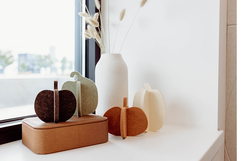 Set of four felt pumpkins in different colors on a white background