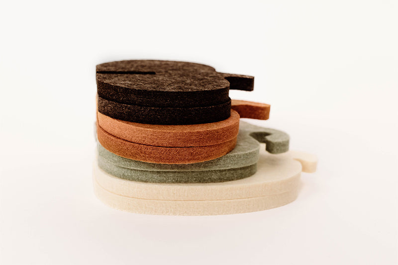 Set of four felt pumpkins in different colors on a white background