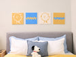 2 felt Charlie tiles and 2 zig zag felt tiles on a wall above a bed with decorative pillows.