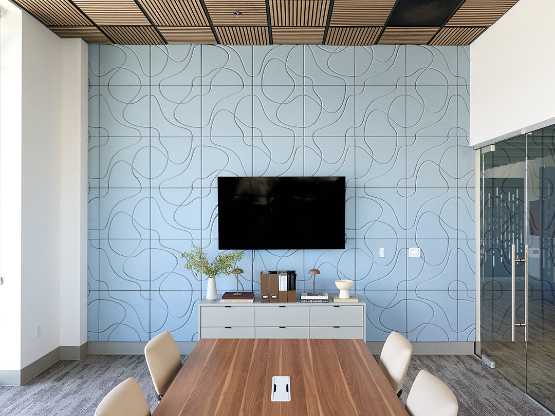Modern conference room with blue patterned wall, wooden table, and chairs.