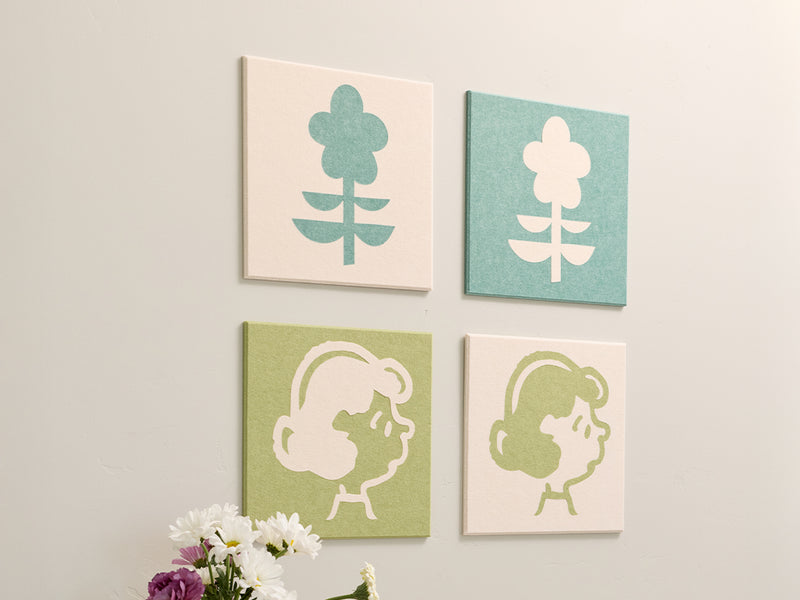 Four square wall art pieces with floral and abstract designs on a white wall.