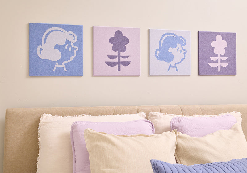 Bedroom with Peanuts Lucy wall art above a bed with a plush toy.