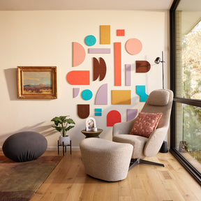 Colorful organic shapes on a wall behind a chair.
