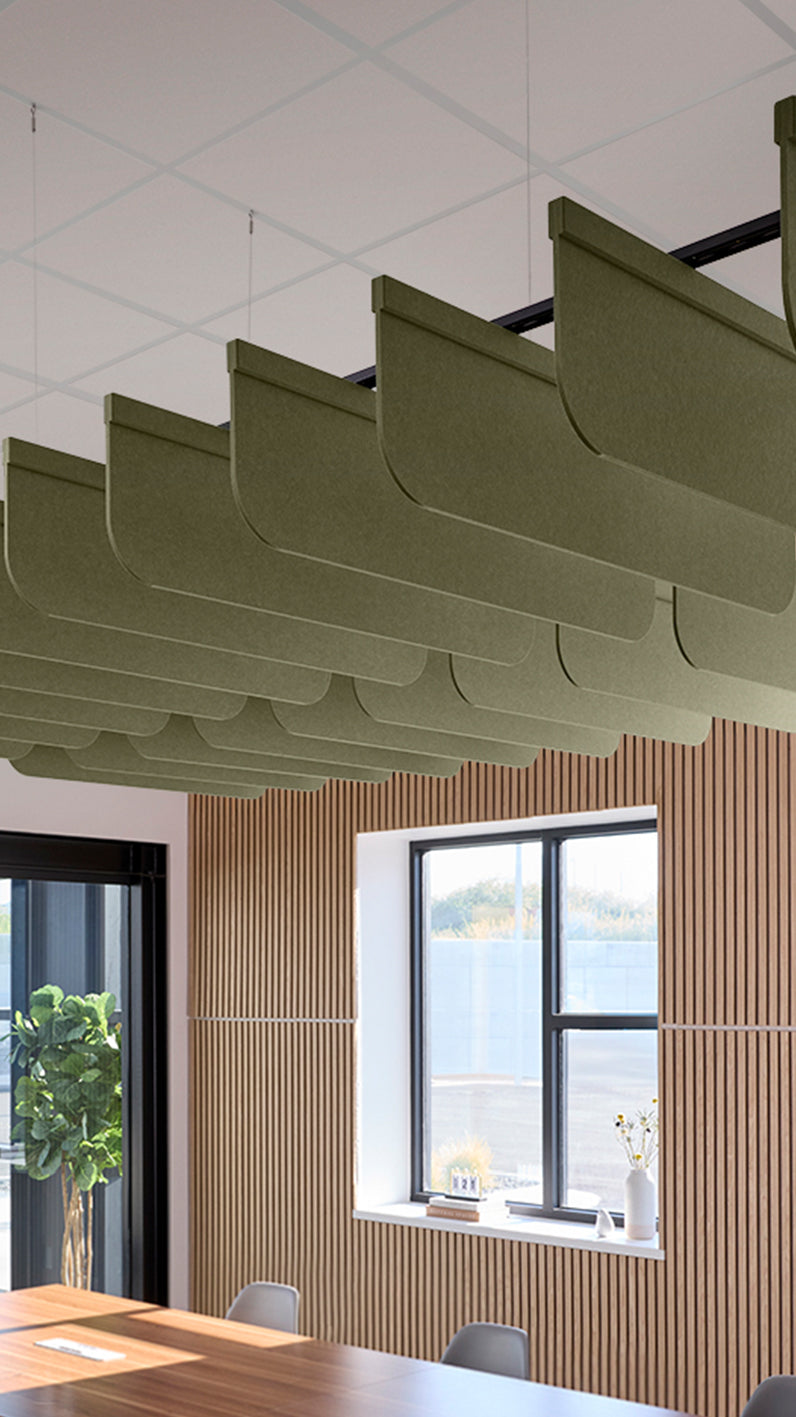 Green acoustic ceiling blade baffles suspended from the ceiling, installed in a conference room. Felt Right's acoustic blade baffles absorb 65% of sound waves, making office spaces quieter and feel more calm.