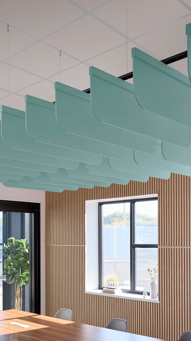 Baby blue acoustic ceiling blade baffles suspended from the ceiling, installed in a conference room. Felt Right's acoustic blade baffles absorb 65% of sound waves, making office spaces quieter and feel more calm.
