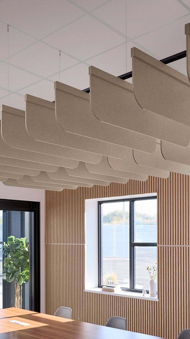 Creamy beige acoustic ceiling blade baffles suspended from the ceiling, installed in a conference room. Felt Right's acoustic blade baffles absorb 65% of sound waves, making office spaces quieter and feel more calm.