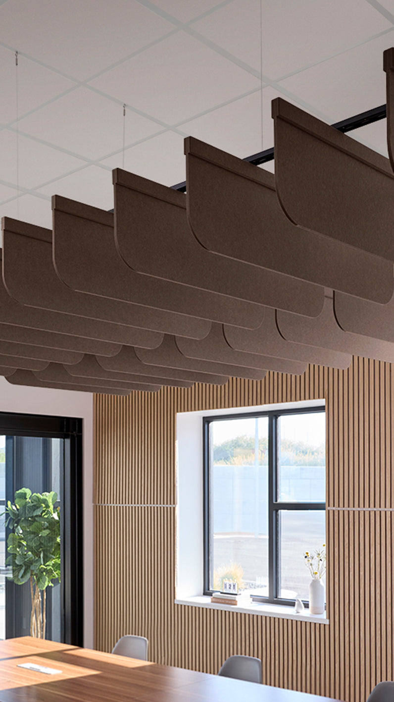 Brown acoustic ceiling blade baffles suspended from the ceiling, installed in a conference room. Felt Right's acoustic blade baffles absorb 65% of sound waves, making office spaces quieter and feel more calm.