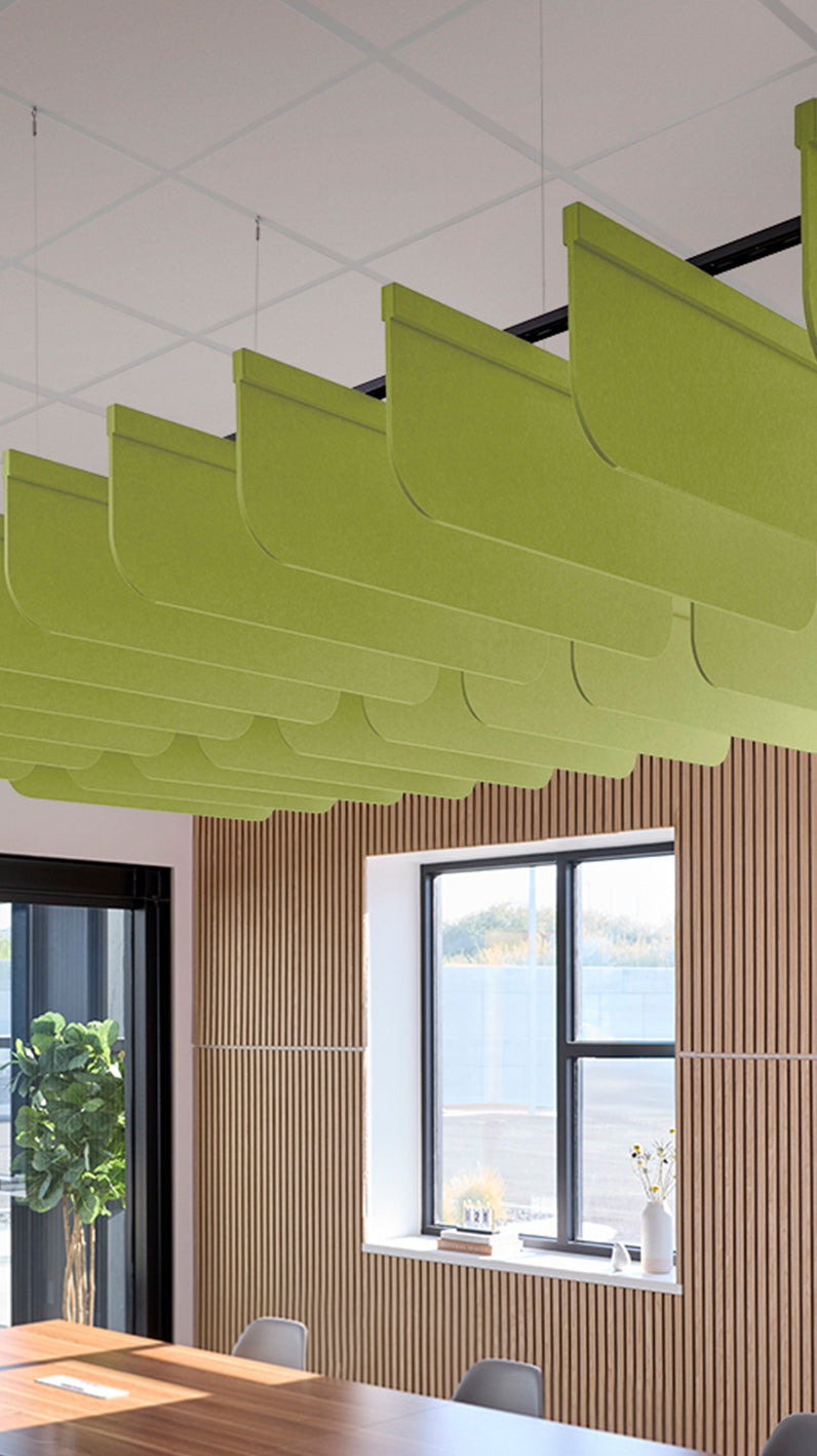 Lime green acoustic ceiling blade baffles suspended from the ceiling, installed in a conference room. Felt Right's acoustic blade baffles absorb 65% of sound waves, making office spaces quieter and feel more calm.