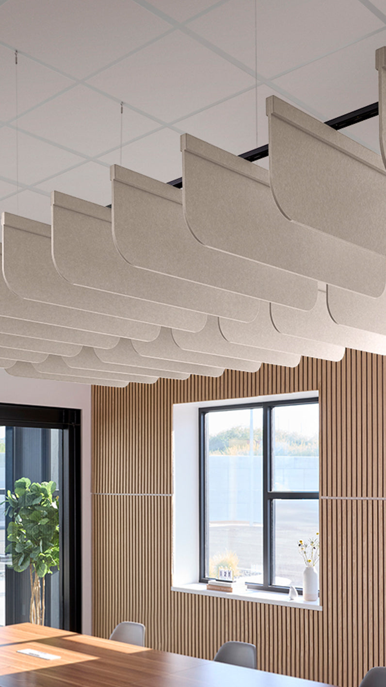 Light grey-brown acoustic ceiling blade baffles suspended from the ceiling, installed in a conference room. Felt Right's acoustic blade baffles absorb 65% of sound waves, making office spaces quieter and feel more calm.