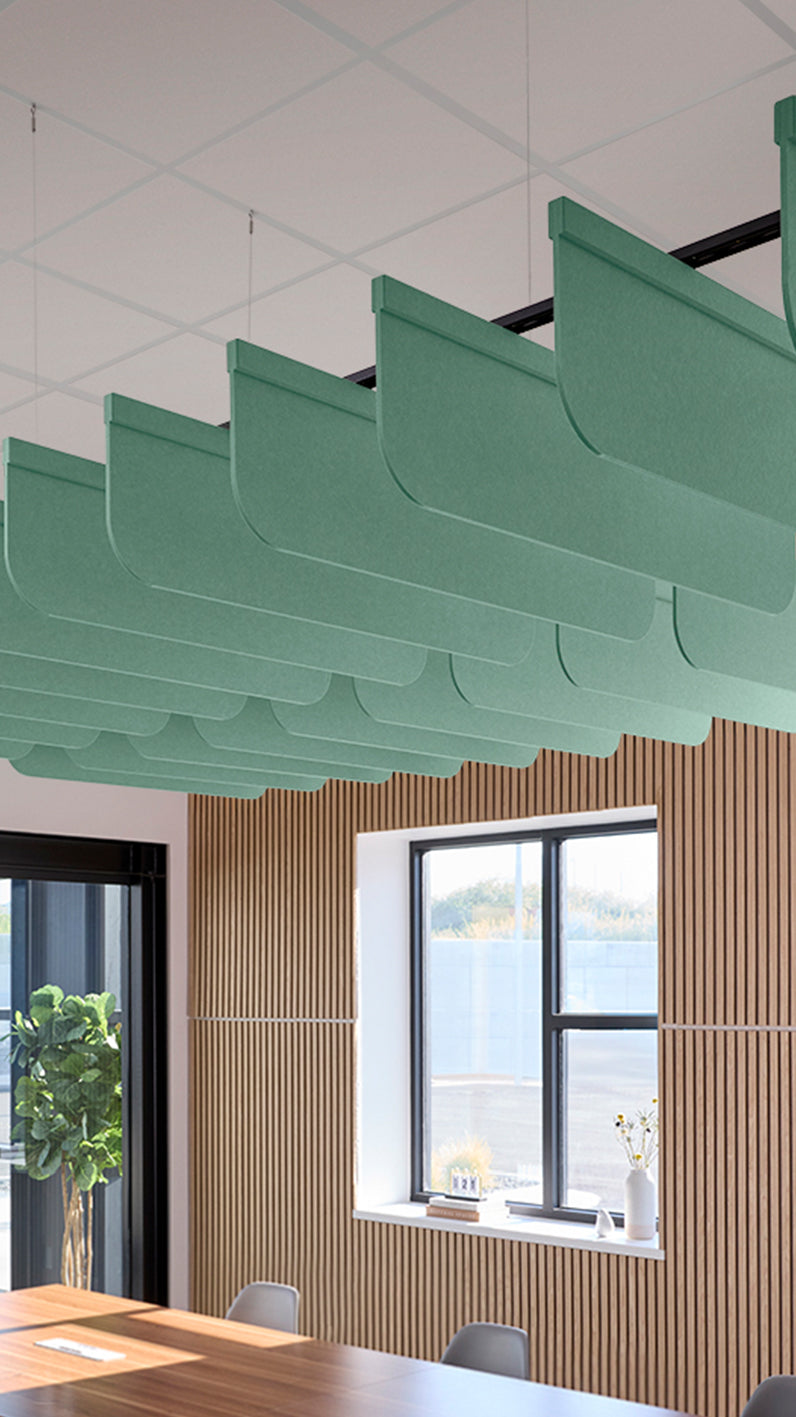 Mint green acoustic ceiling blade baffles suspended from the ceiling, installed in a conference room. Felt Right's acoustic blade baffles absorb 65% of sound waves, making office spaces quieter and feel more calm.