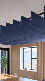 Dark blue acoustic ceiling blade baffles suspended from the ceiling, installed in a conference room. Felt Right's acoustic blade baffles absorb 65% of sound waves, making office spaces quieter and feel more calm.
