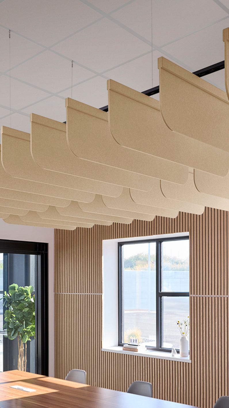 Light tan acoustic ceiling blade baffles suspended from the ceiling, installed in a conference room. Felt Right's acoustic blade baffles absorb 65% of sound waves, making office spaces quieter and feel more calm.