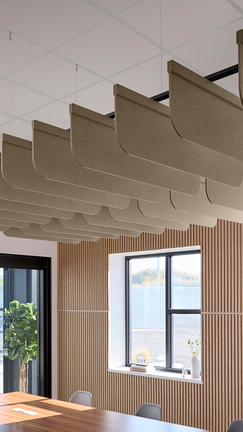 Light brown acoustic ceiling blade baffles suspended from the ceiling, installed in a conference room. Felt Right's acoustic blade baffles absorb 65% of sound waves, making office spaces quieter and feel more calm.