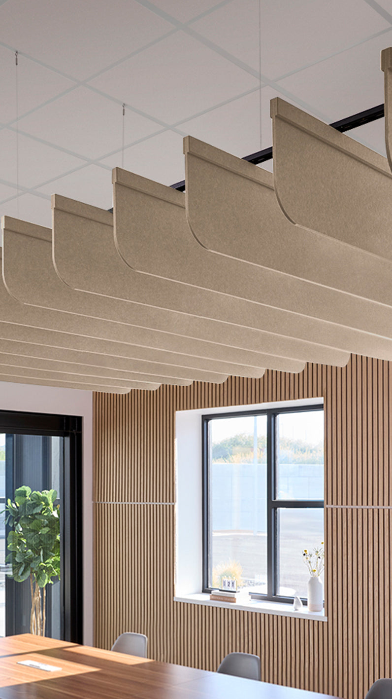 Creamy beige acoustic ceiling blade baffles suspended from the ceiling, installed in a conference room. Felt Right's acoustic blade baffles absorb 65% of sound waves, making office spaces quieter and feel more calm.