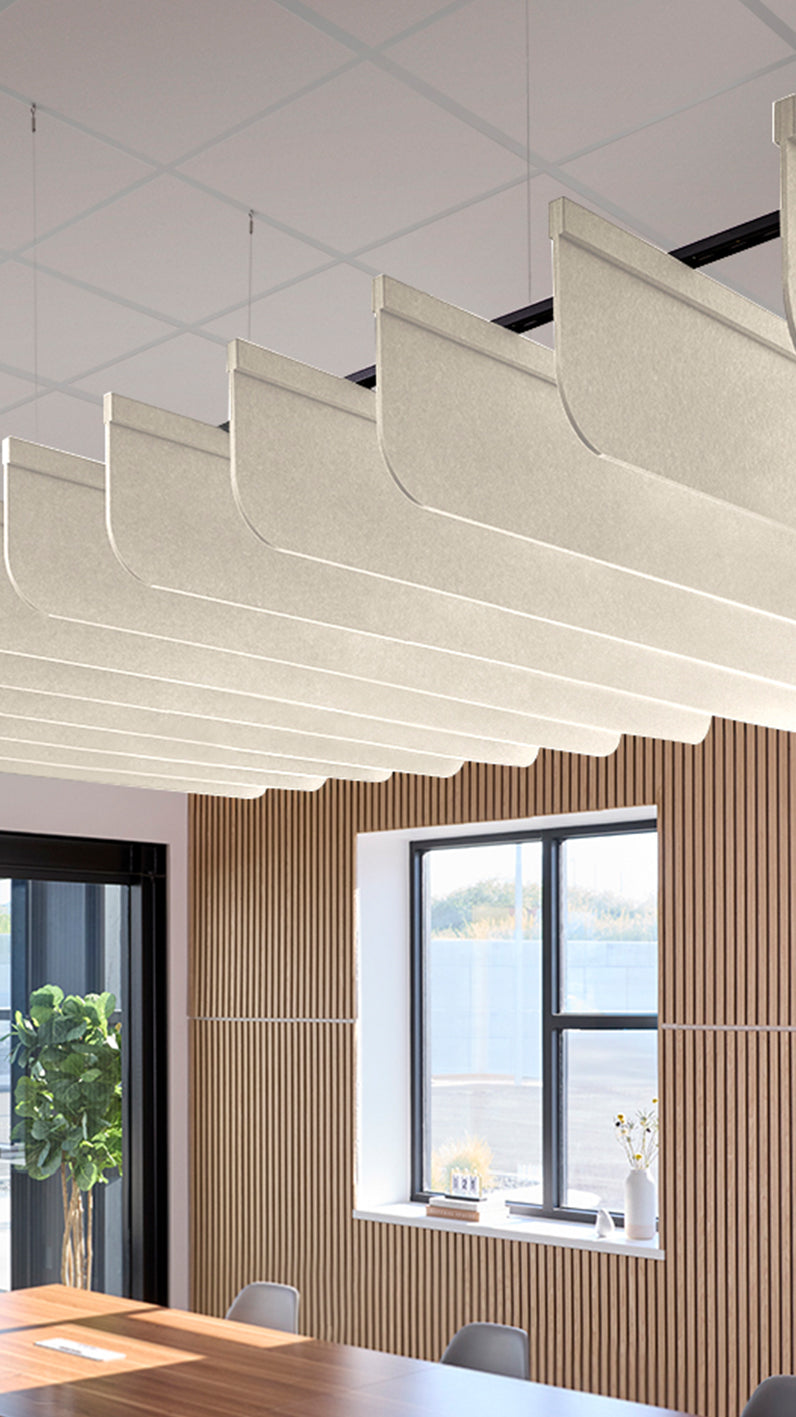 Cream acoustic ceiling blade baffles suspended from the ceiling, installed in a conference room. Felt Right's acoustic blade baffles absorb 65% of sound waves, making office spaces quieter and feel more calm.