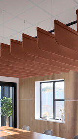 Reddish-brown acoustic ceiling blade baffles suspended from the ceiling, installed in a conference room. Felt Right's acoustic blade baffles absorb 65% of sound waves, making office spaces quieter and feel more calm.