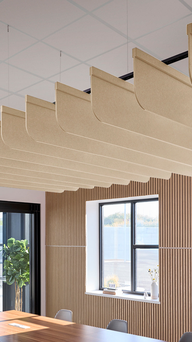 Light tan acoustic ceiling blade baffles suspended from the ceiling, installed in a conference room. Felt Right's acoustic blade baffles absorb 65% of sound waves, making office spaces quieter and feel more calm.