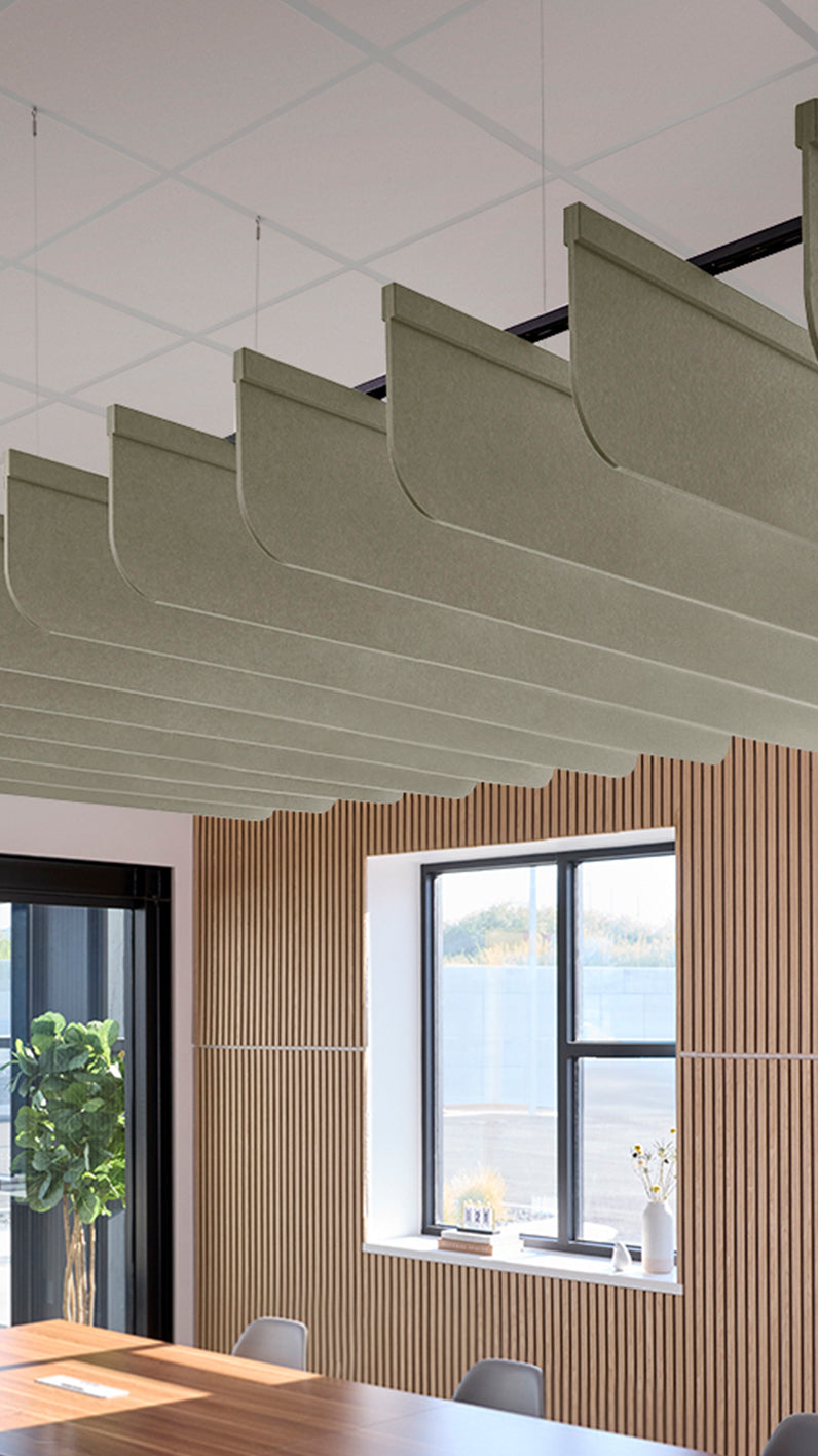 Soft green acoustic ceiling blade baffles suspended from the ceiling, installed in a conference room. Felt Right's acoustic blade baffles absorb 65% of sound waves, making office spaces quieter and feel more calm.