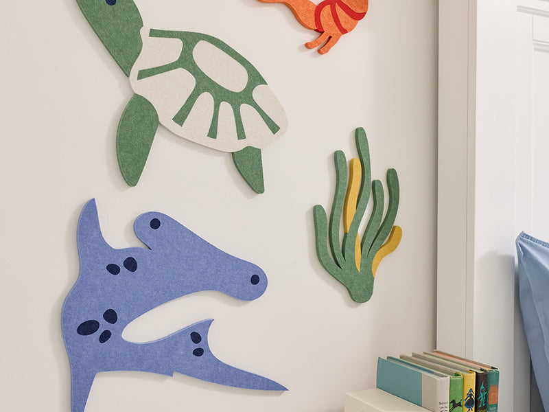 Colorful sea-themed wall decorations on a white wall.