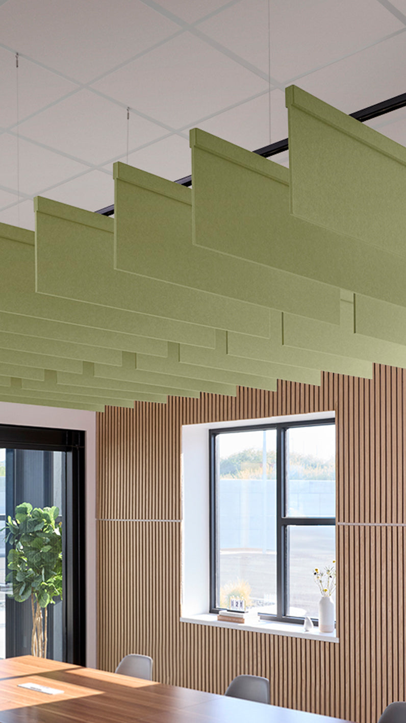 Light green acoustic ceiling blade baffles suspended from the ceiling, installed in a conference room. Felt Right's acoustic blade baffles absorb 65% of sound waves, making office spaces quieter and feel more calm.