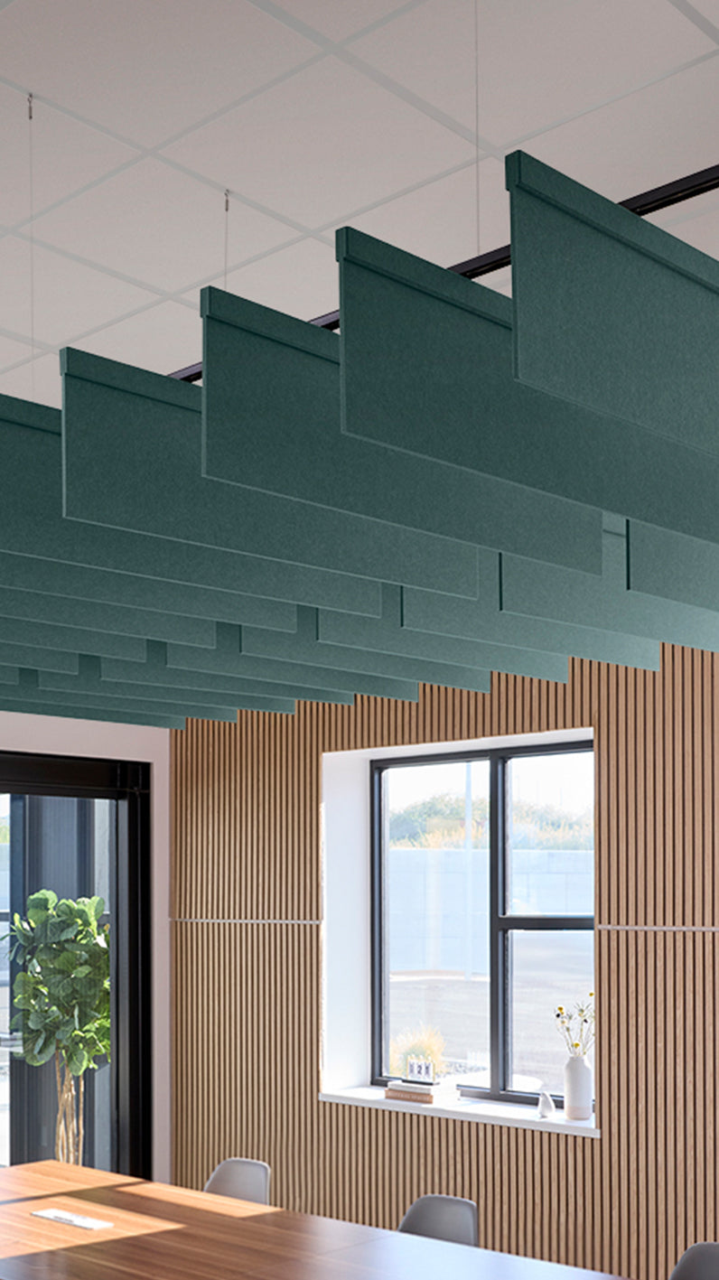 Blue-green acoustic ceiling blade baffles suspended from the ceiling, installed in a conference room. Felt Right's acoustic blade baffles absorb 65% of sound waves, making office spaces quieter and feel more calm.