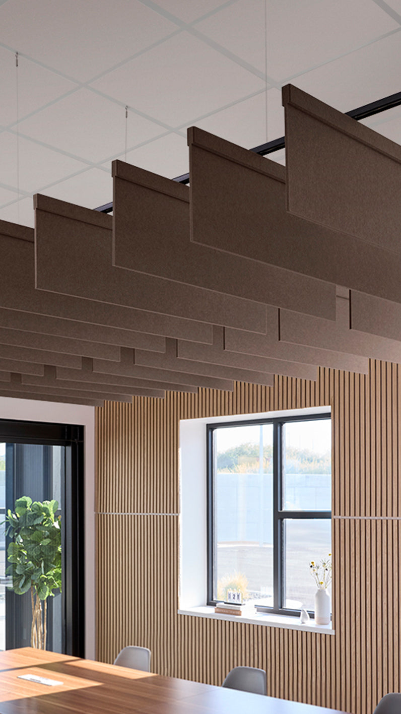 Brown acoustic ceiling blade baffles suspended from the ceiling, installed in a conference room. Felt Right's acoustic blade baffles absorb 65% of sound waves, making office spaces quieter and feel more calm.