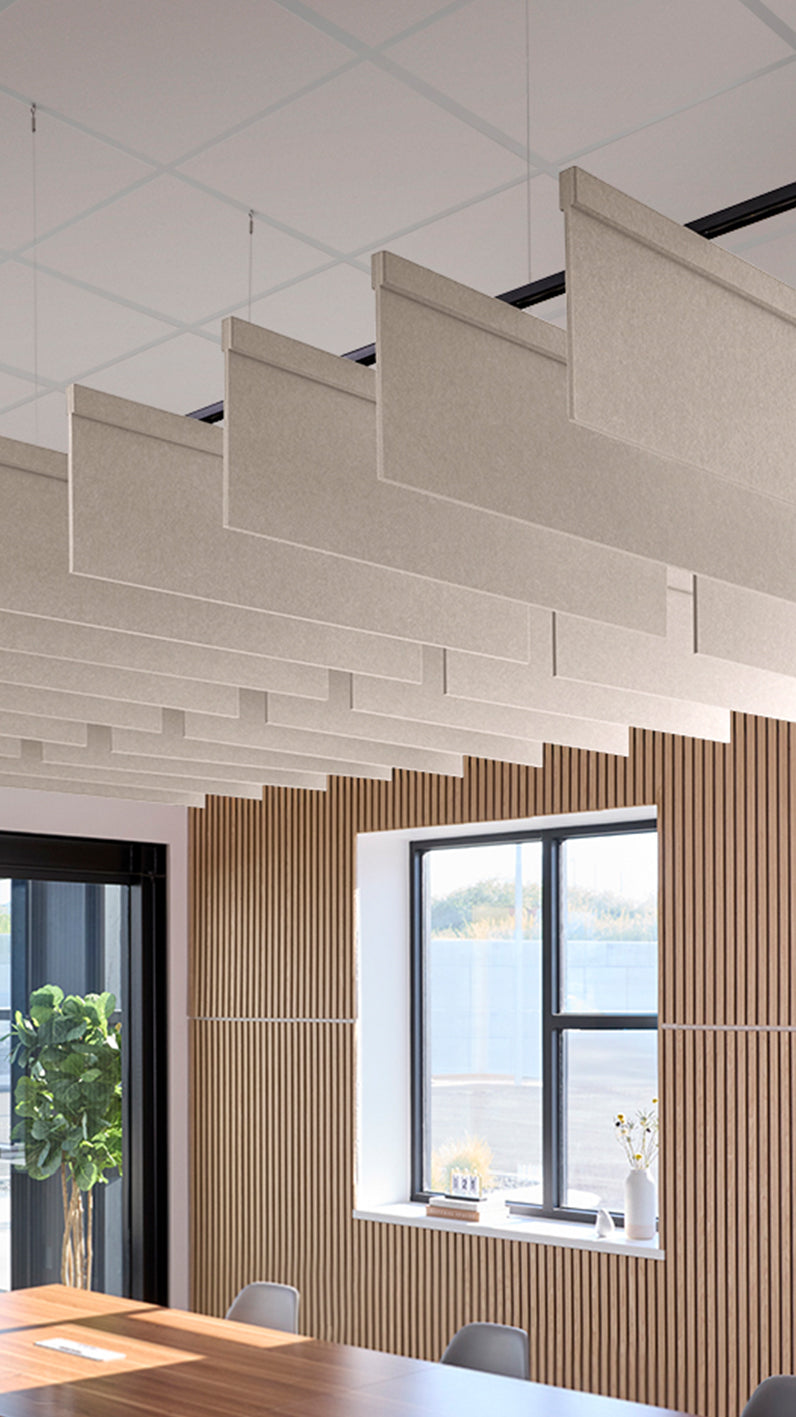 Light grey-brown acoustic ceiling blade baffles suspended from the ceiling, installed in a conference room. Felt Right's acoustic blade baffles absorb 65% of sound waves, making office spaces quieter and feel more calm.