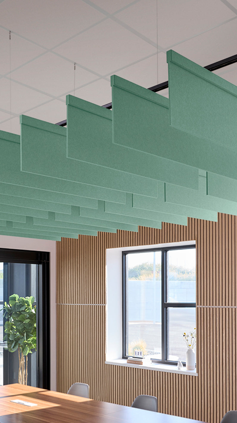 Mint green acoustic ceiling blade baffles suspended from the ceiling, installed in a conference room. Felt Right's acoustic blade baffles absorb 65% of sound waves, making office spaces quieter and feel more calm.