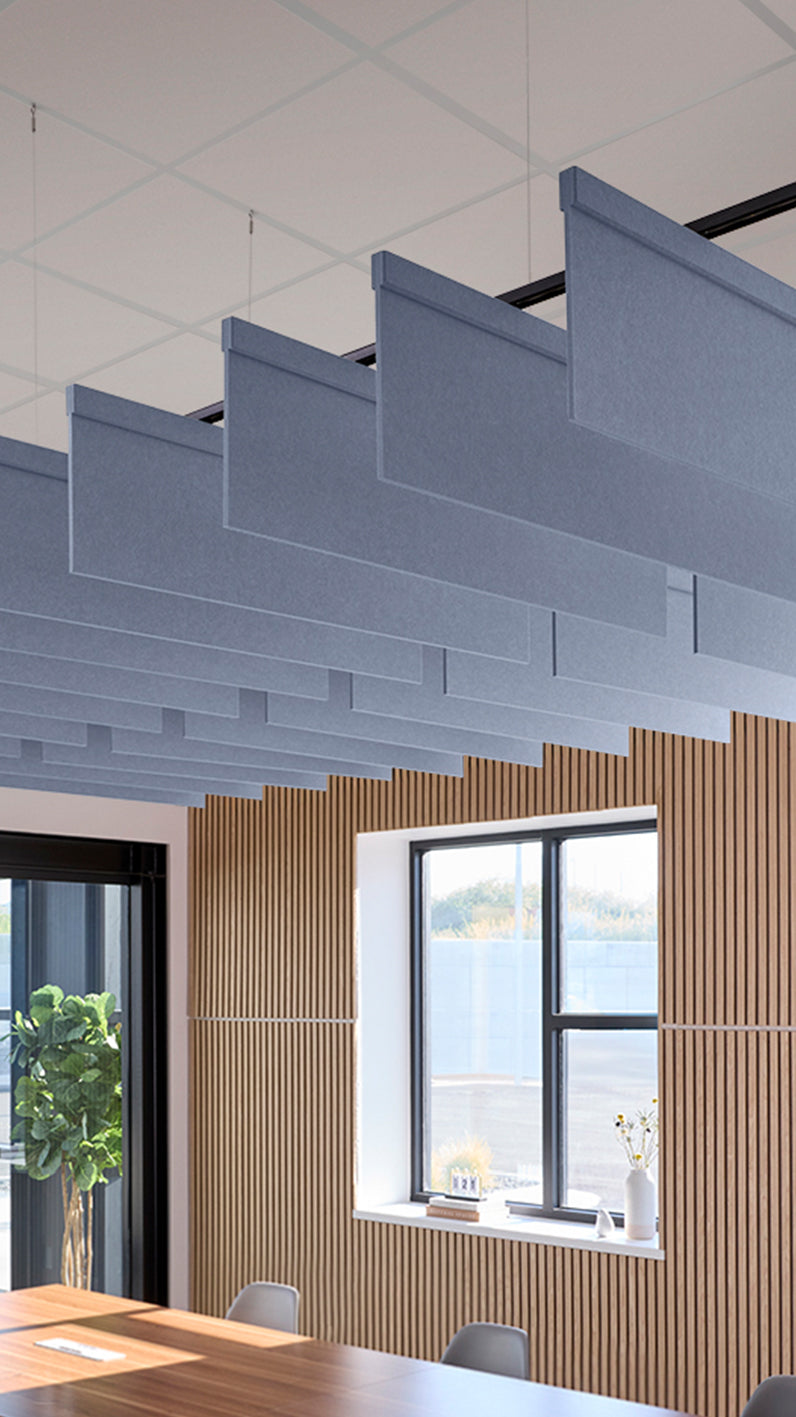 Purplish-blue acoustic ceiling blade baffles suspended from the ceiling, installed in a conference room. Felt Right's acoustic blade baffles absorb 65% of sound waves, making office spaces quieter and feel more calm.