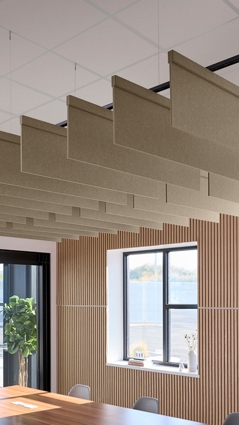 Light brown acoustic ceiling blade baffles suspended from the ceiling, installed in a conference room. Felt Right's acoustic blade baffles absorb 65% of sound waves, making office spaces quieter and feel more calm.