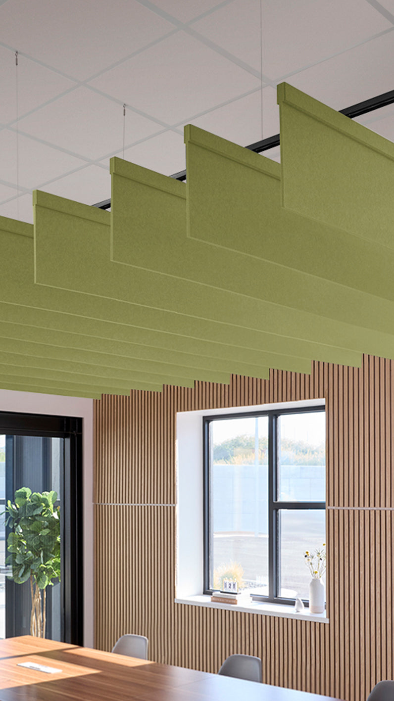 Light green acoustic ceiling blade baffles suspended from the ceiling, installed in a conference room. Felt Right's acoustic blade baffles absorb 65% of sound waves, making office spaces quieter and feel more calm.