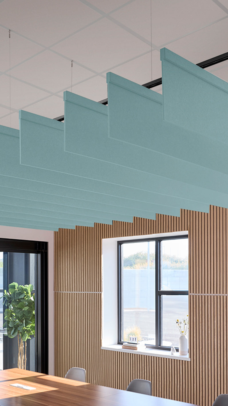 Baby Blue acoustic ceiling blade baffles suspended from the ceiling, installed in a conference room. Felt Right's acoustic blade baffles absorb 65% of sound waves, making office spaces quieter and feel more calm.