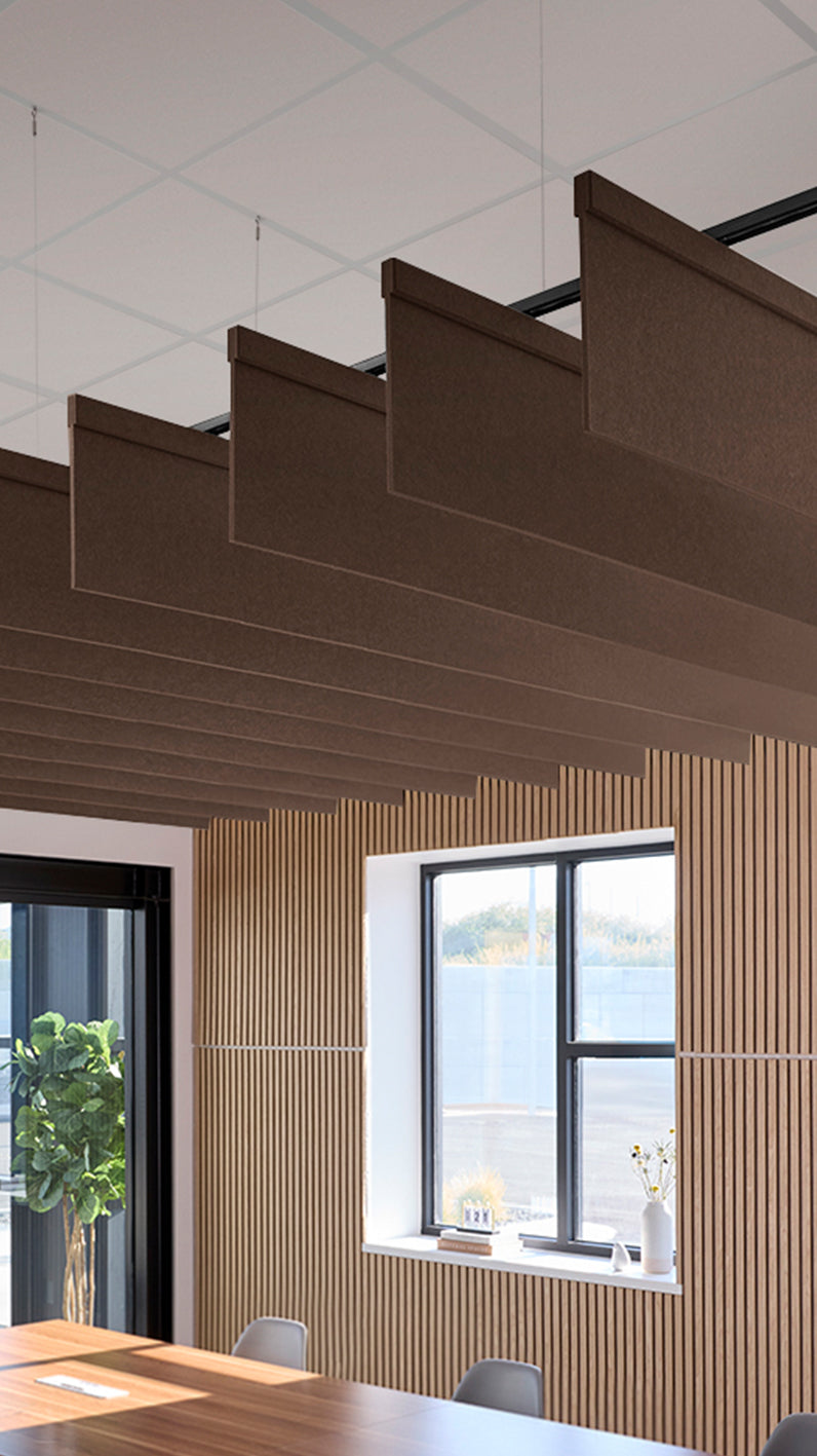 Brown acoustic ceiling blade baffles suspended from the ceiling, installed in a conference room. Felt Right's acoustic blade baffles absorb 65% of sound waves, making office spaces quieter and feel more calm.