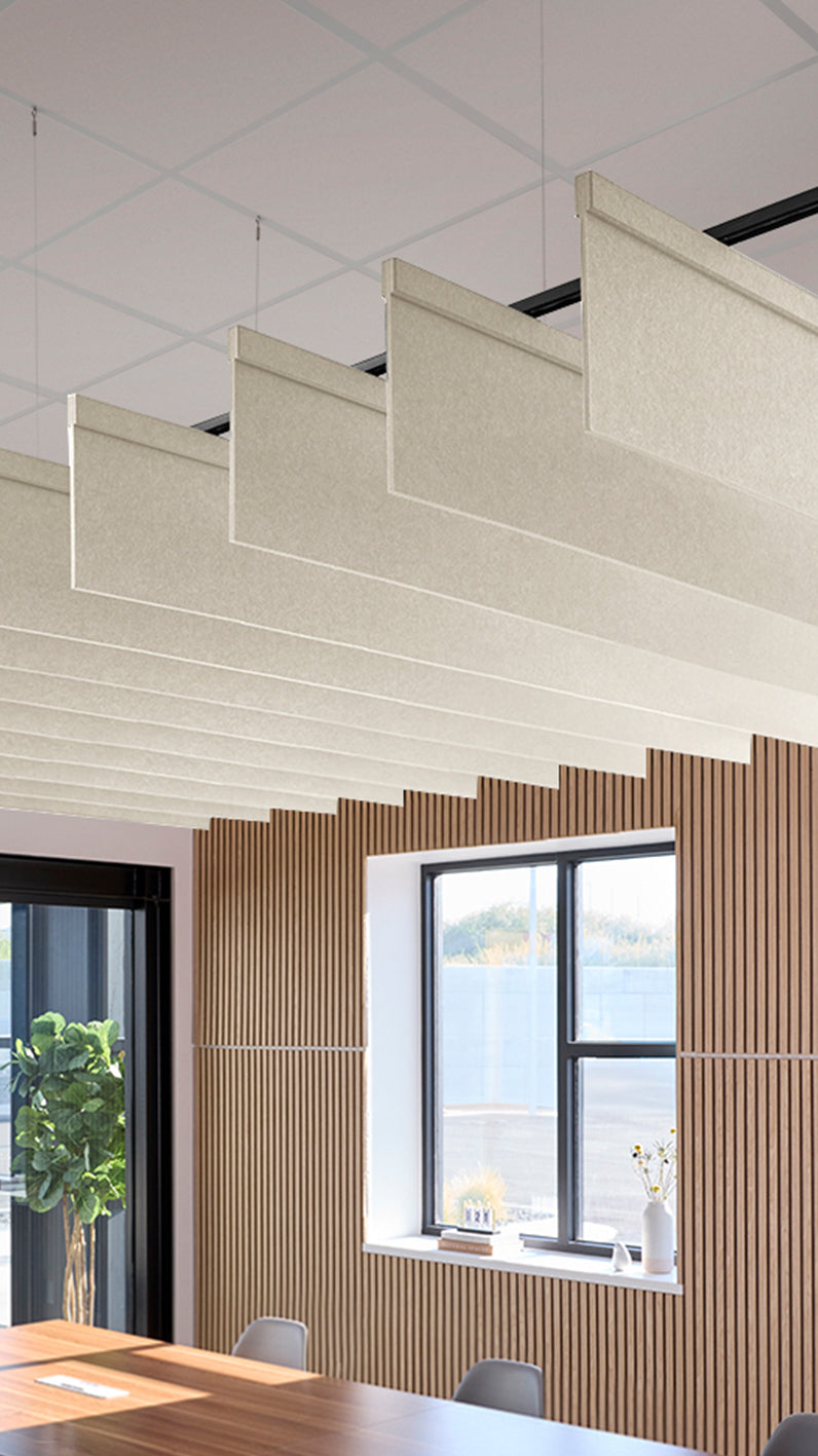 Cream acoustic ceiling blade baffles suspended from the ceiling, installed in a conference room. Felt Right's acoustic blade baffles absorb 65% of sound waves, making office spaces quieter and feel more calm.