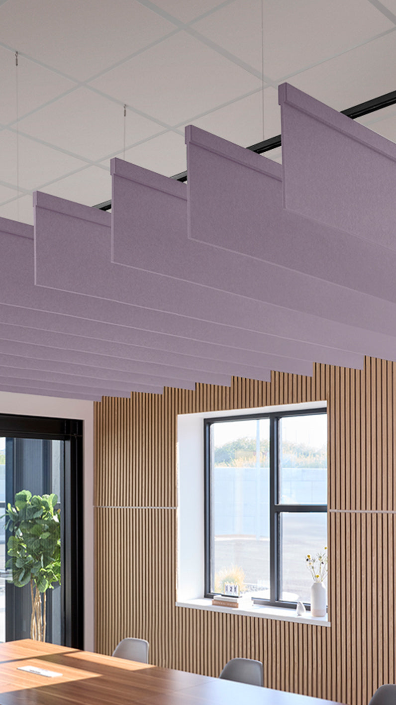 Light purple acoustic ceiling blade baffles suspended from the ceiling, installed in a conference room. Felt Right's acoustic blade baffles absorb 65% of sound waves, making office spaces quieter and feel more calm.