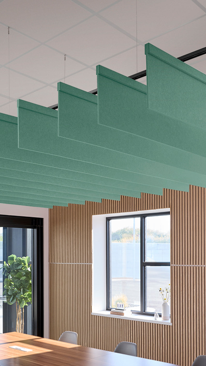Mint green acoustic ceiling blade baffles suspended from the ceiling, installed in a conference room. Felt Right's acoustic blade baffles absorb 65% of sound waves, making office spaces quieter and feel more calm.