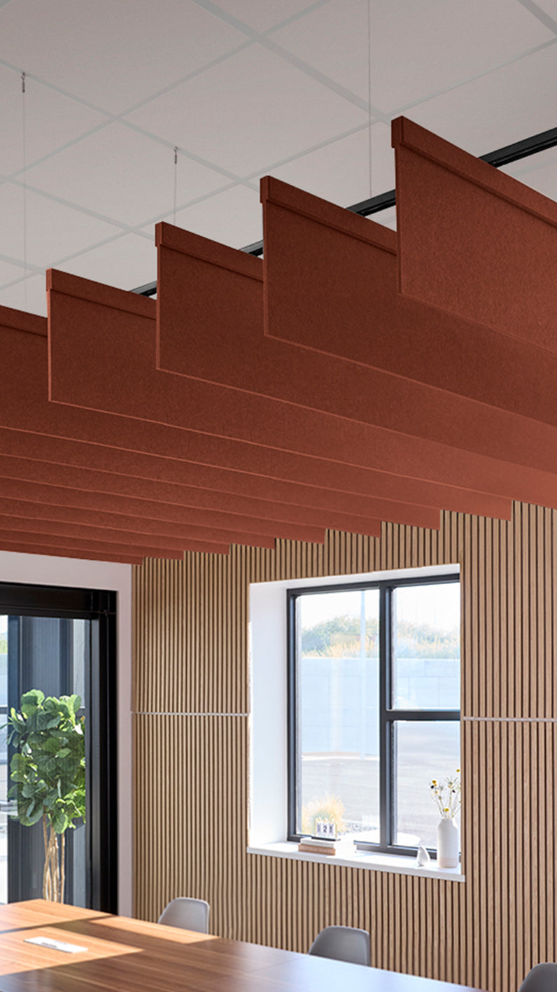 Reddish-brown acoustic ceiling blade baffles suspended from the ceiling, installed in a conference room. Felt Right's acoustic blade baffles absorb 65% of sound waves, making office spaces quieter and feel more calm.