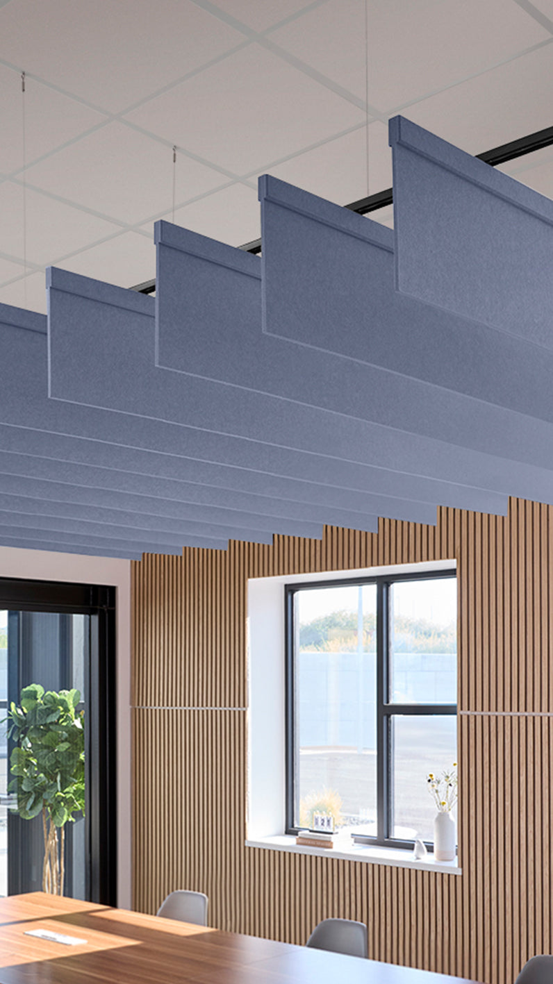 Purplish-blue acoustic ceiling blade baffles suspended from the ceiling, installed in a conference room. Felt Right's acoustic blade baffles absorb 65% of sound waves, making office spaces quieter and feel more calm.