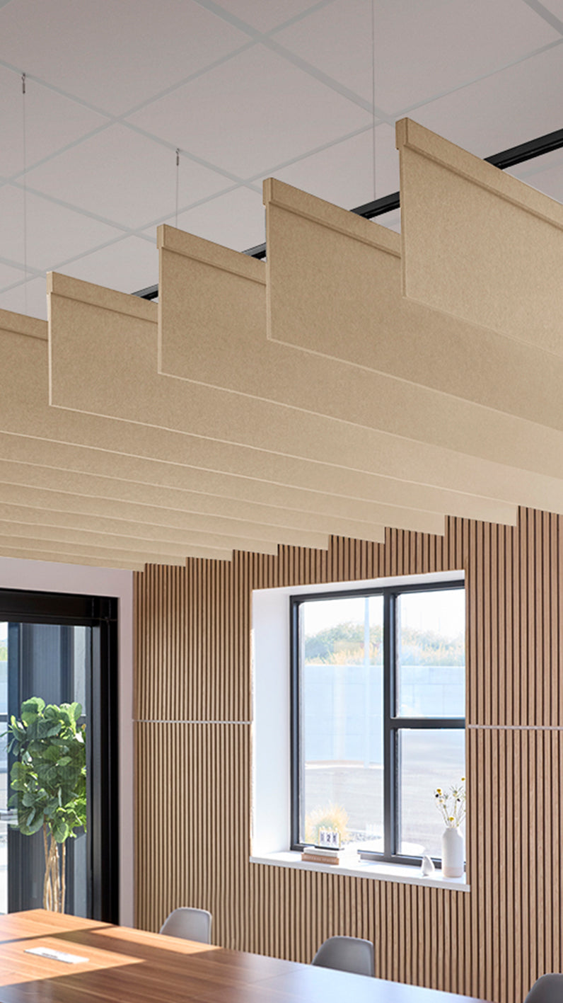 Light tan acoustic ceiling blade baffles suspended from the ceiling, installed in a conference room. Felt Right's acoustic blade baffles absorb 65% of sound waves, making office spaces quieter and feel more calm.