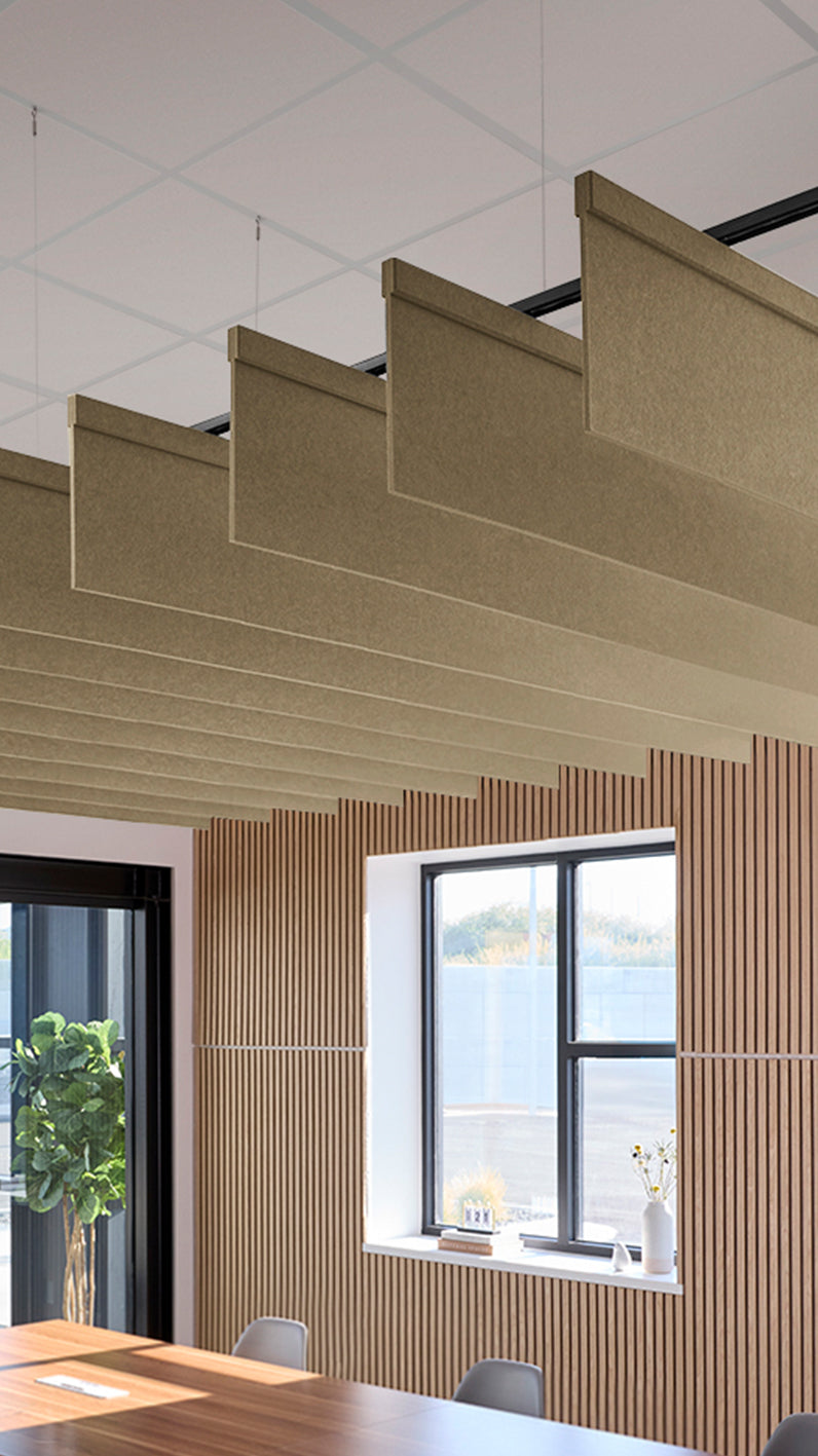 Light brown acoustic ceiling blade baffles suspended from the ceiling, installed in a conference room. Felt Right's acoustic blade baffles absorb 65% of sound waves, making office spaces quieter and feel more calm.