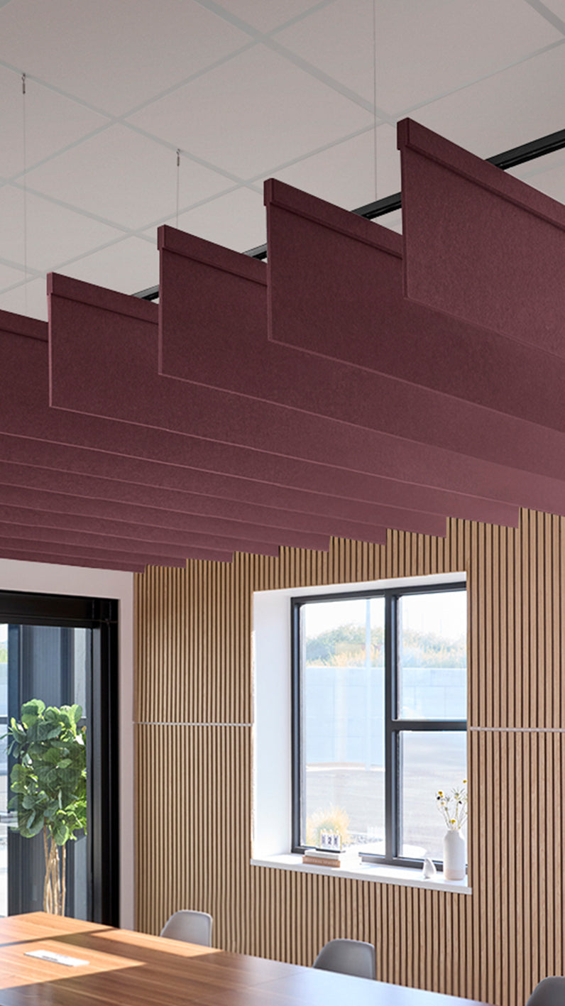 Deep reddish-purple acoustic ceiling blade baffles suspended from the ceiling, installed in a conference room. Felt Right's acoustic blade baffles absorb 65% of sound waves, making office spaces quieter and feel more calm.