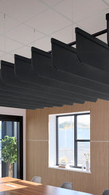 Black curved acoustic baffles suspended from ceiling in modern office space with wooden wall paneling.