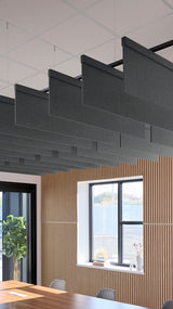 Dark gray acoustic baffles suspended horizontally from ceiling in modern office space above wooden wall paneling.