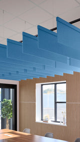 Blue rectangular acoustic baffles suspended from ceiling in modern office space with wooden wall paneling.